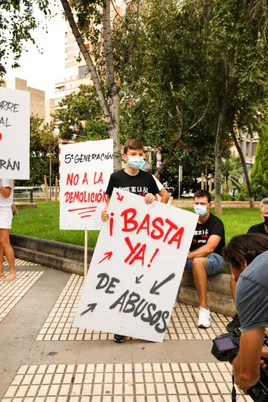 Niño con un cartel «¡Basta ya! de abusos» en una concentración de vecinos
